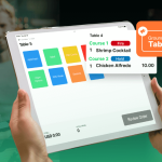 Waiter using waiter app on ipad assisting customers.